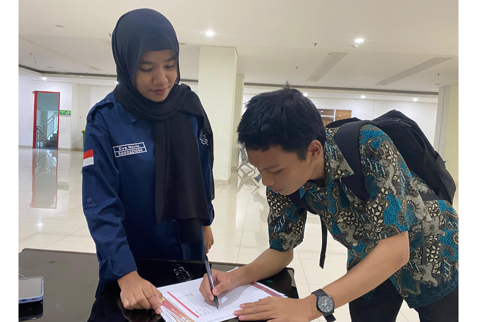 Gambar panitia donor darah mengarahkan pendonor mengisi registrasi