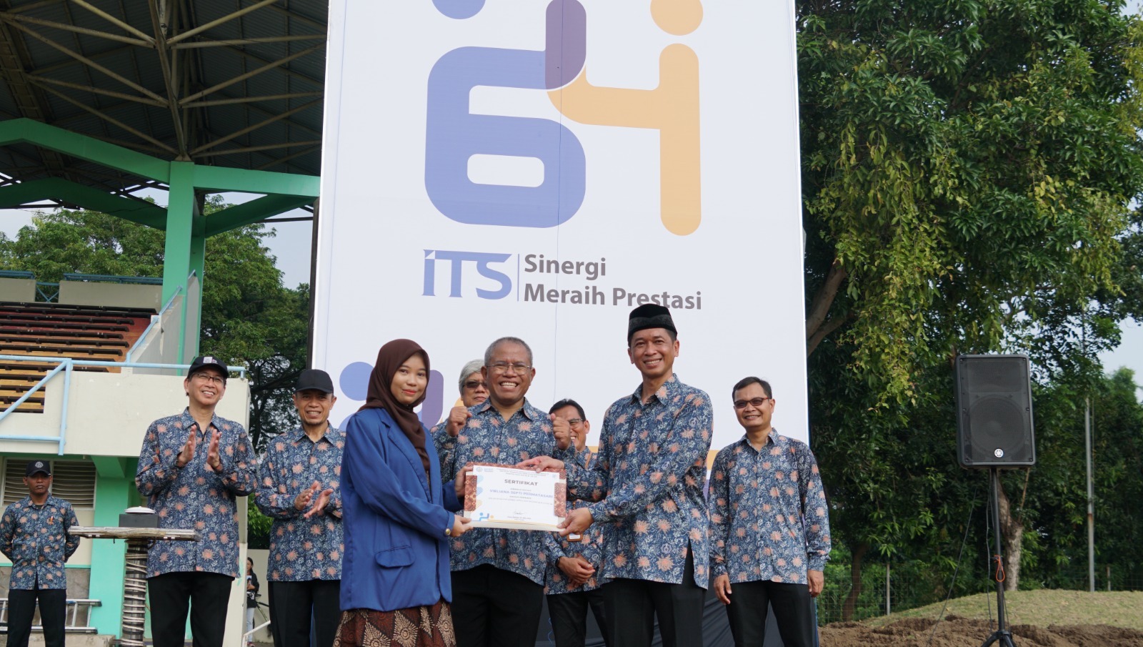 Rektor ITS Ir Bambang Pramujati ST MSc Eng PhD saat menyerahkan sertifikat penghargaan kepada desainer logo Dies Natalis ke-64 ITS terpilih, Virliana Septi Permatasari 