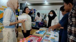 Mahasiswa Desain Produk ITS yang menjelaskan purnawarupa permainan sensori bagi pelajar