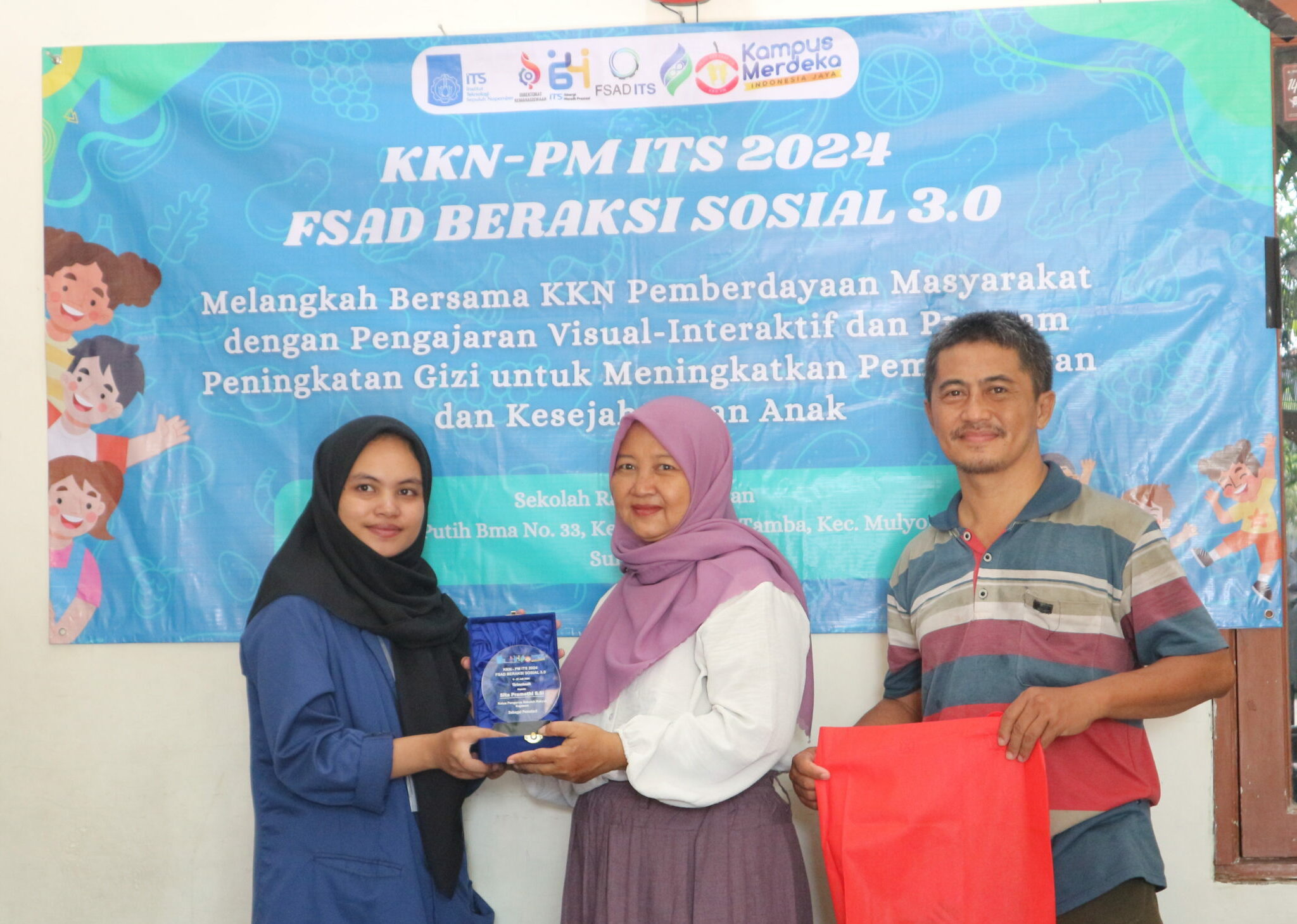dari kiri Ketua Pelaksana KKN FSAD Beraksi 3.0 Firda Zaidah Ilma menyerahkan piagam kepada Ketua Yayasan Sekolah Rakyat Kejawan Sita Pramesthi.