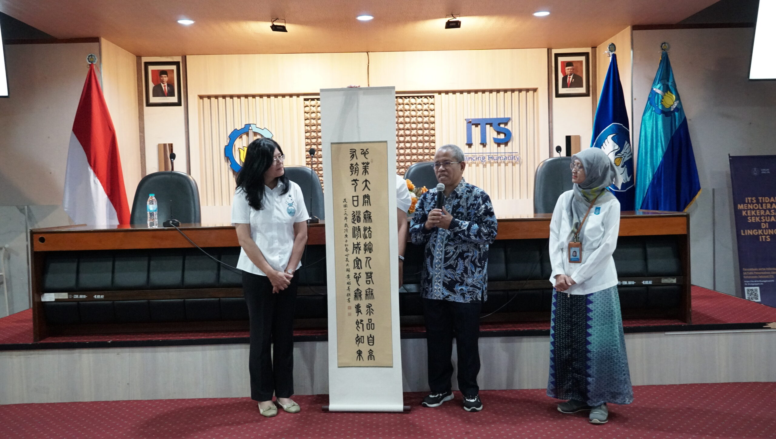 Dekan Fakultas Desain Kreatif dan Bisnis Digital (FDKBD) ITS (berbatik biru) bersama dengan Prof Jenny Huang (kiri) ketika pemberian cinderamata kaligrafi Cina dari Yuntech University