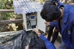 Foto Mahasiswa ITS saat melakukan pengecekan pda alat pemantauan kualiatans air untuk kolam udang