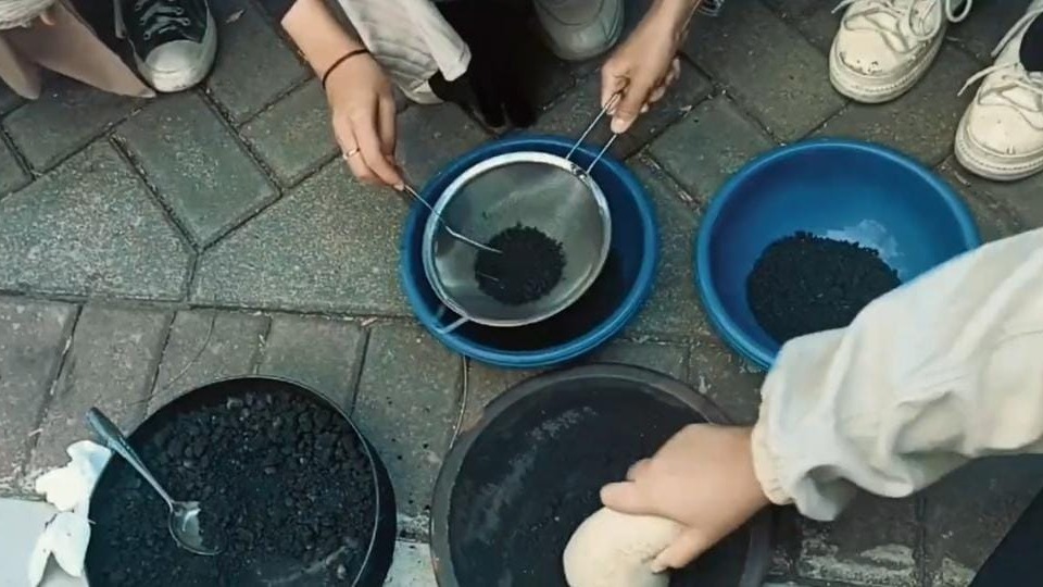 Mahasiswa ITS anggota KKN Abmas sedang menghaluskan bahan baku biobriket yang telah diaktivasi