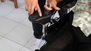 Gambar tim KKN Abmas melakukan pencerdasan kendali joystick kursi roda pada penyandang disabilitas