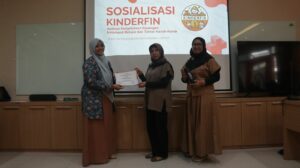 Ketua tim Abmas, Adhatus Solichah Ahmadiyah, S.Kom, M.Sc (dari kiri) saat memberikan cinderamata kepada salah satu mitra tim Abmas dalam sesi sosialisasi dan pelatihan aplikasi Kinderfin