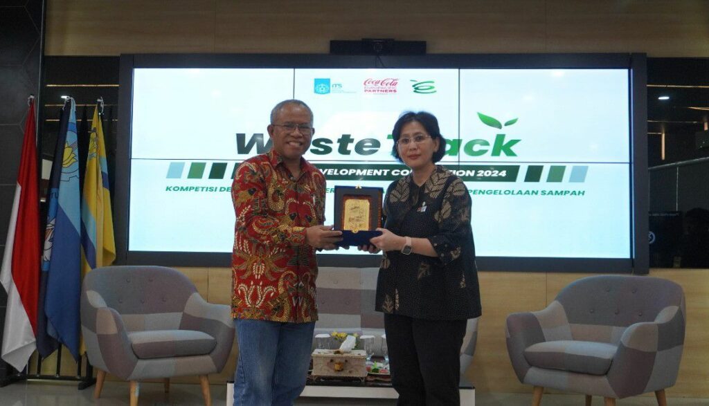 Wakil Rektor III ITS Imam Baihaqi ST MSc PhD (kiri) dan Direktur Public Affairs, Communication, and Sustainability CCEP Indonesia, Lucia Karina (kanan) saat penyerahan simbolis kerja sama untuk ITS dengan CCEP Indonesia melalui kompetisi WasteTrack 2024