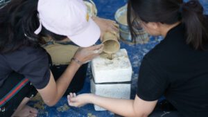 Anggota tim KKN Abmas ITS mendemonstrasikan pembuatan kerajinan gerabah dengan teknik cetak cor