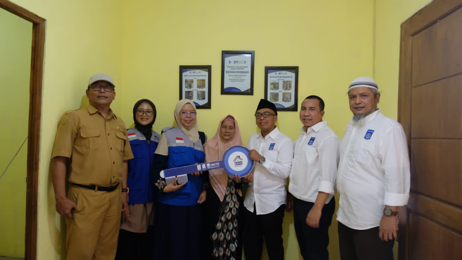 Koordinator Operasional YMI ITS drh Ika Putri Rahma Daniya (tiga dari kiri) saat menyerahkan kunci hasil bedah rumah tidak layak huni kepada Marpatih (tengah)