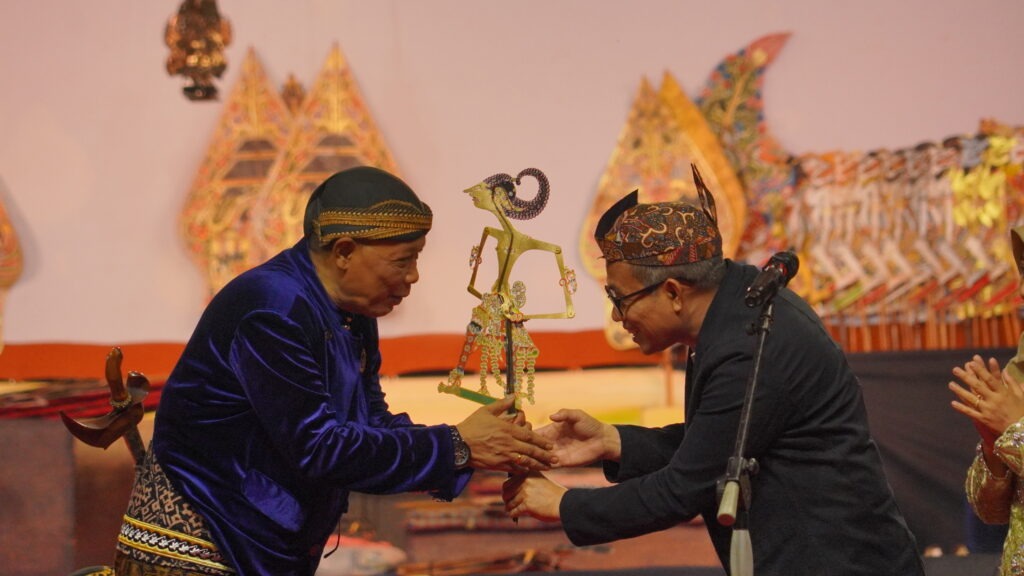 Simbolisasi penyerahan wayang kulit dari Wakil Rektor II Bidang Perencanaan, Keuangan, dan Sarana Prasarana ITS Dr Machsus ST MT (kanan) kepada Dalang Pagelaran Wayang Ki Minto Darsono (kiri)
