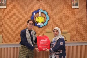 Gambar Octaviyanti Dwi saat menerima pemberian cinderamata dari perwakilan UNIMY