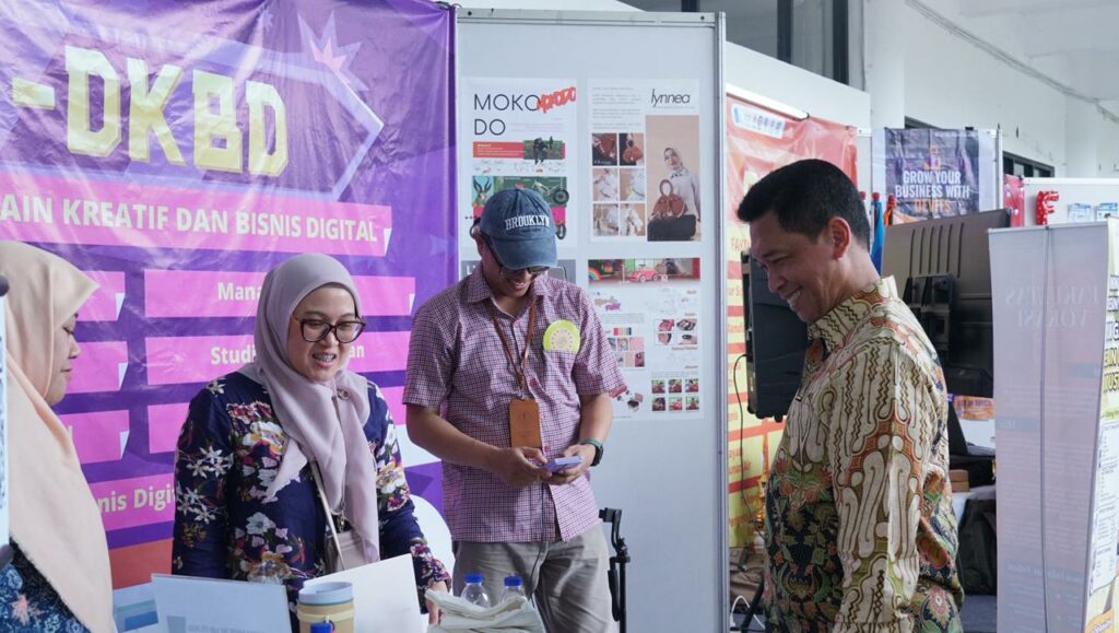 Rektor ITS Prof Dr (HC) Ir Bambang Pramujati ST MSc Eng PhD (kanan) saat mengunjungi stan pameran Fakultas Desain Kreatif dan Bisnis Digital (FDKBD) ITS dalam kegiatan Ini Lho ITS 2026 di Grha Sepuluh Nopember ITS