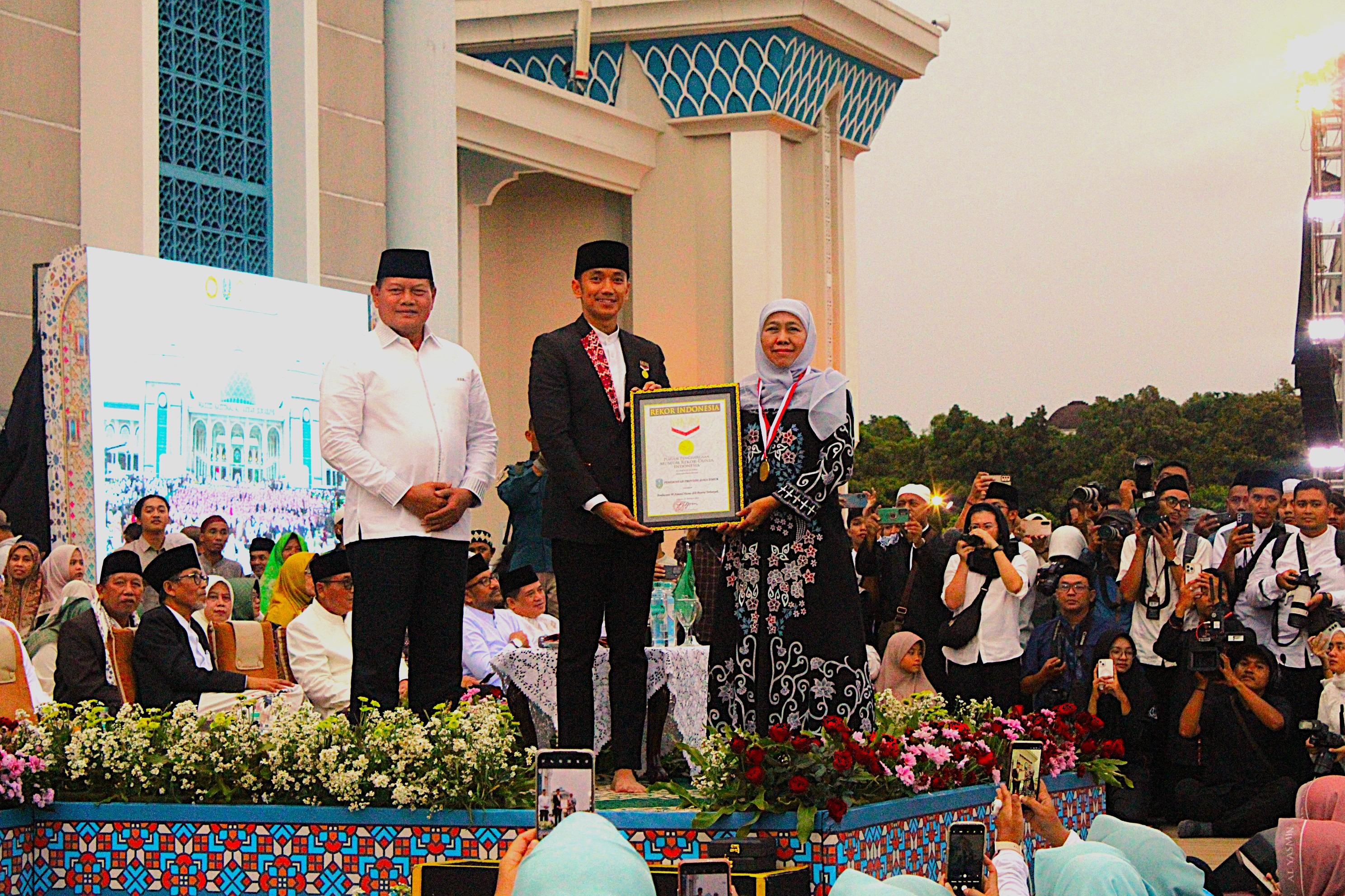Gambar Senior Manajer Museum Rekor Dunia Indonesia (MURI) Triyono menyerahkan penghargaan 12.000 porsi jus kurma dari Raja Salman untuk sajian bukber kepada Gubernur Jawa Timur Khofifah Indar Parawansa