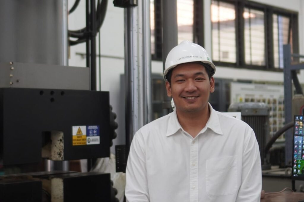 Danny Triputra Setiamanah ST MT MEng, lulusan doktor dari Departemen Teknik Sipil ITS, berpose dengan alat uji Indonesia Slab Track