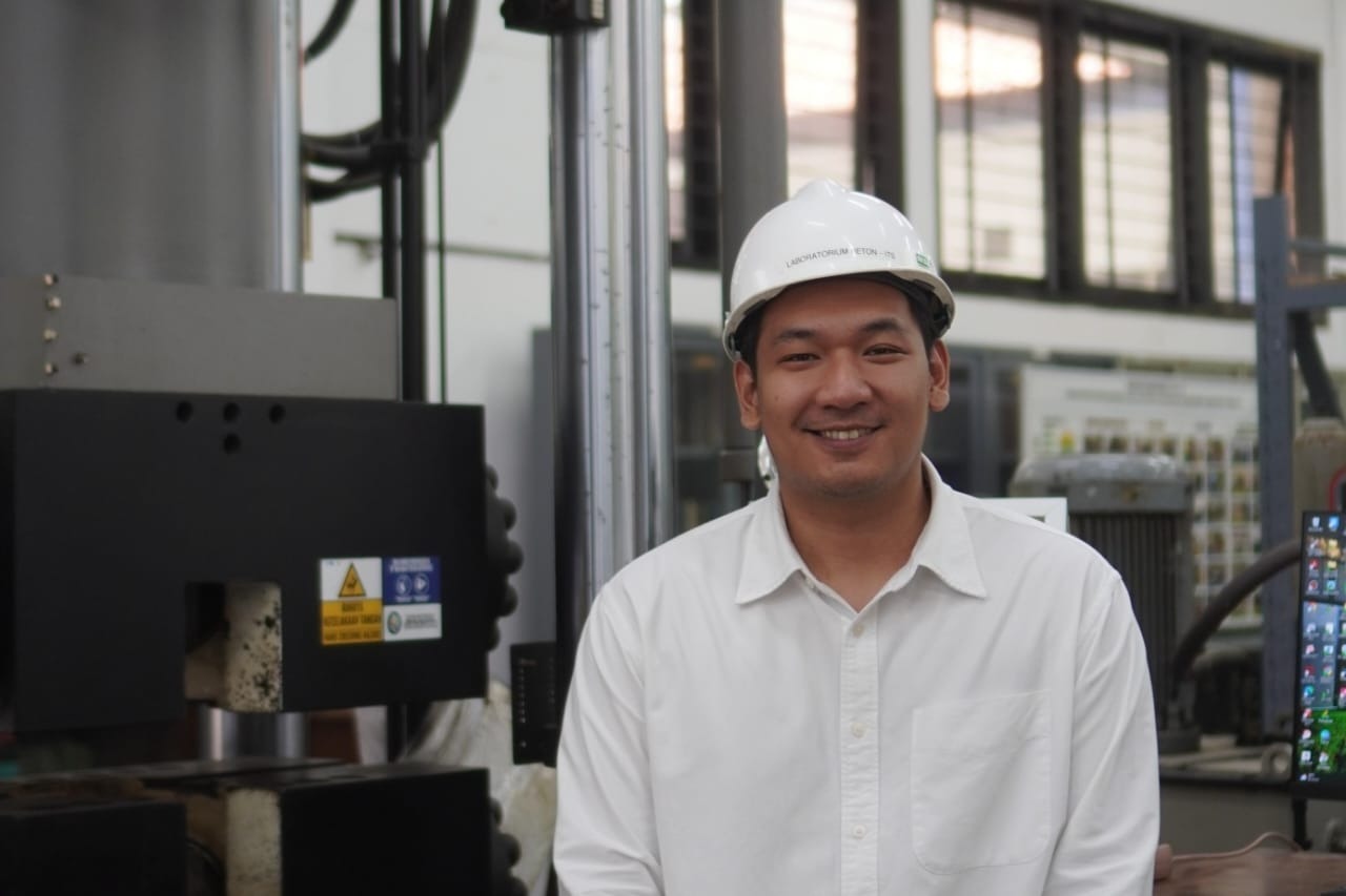 Danny Triputra Setiamanah ST MT MEng, lulusan doktor dari Departemen Teknik Sipil ITS, berpose dengan alat uji Indonesia Slab Track