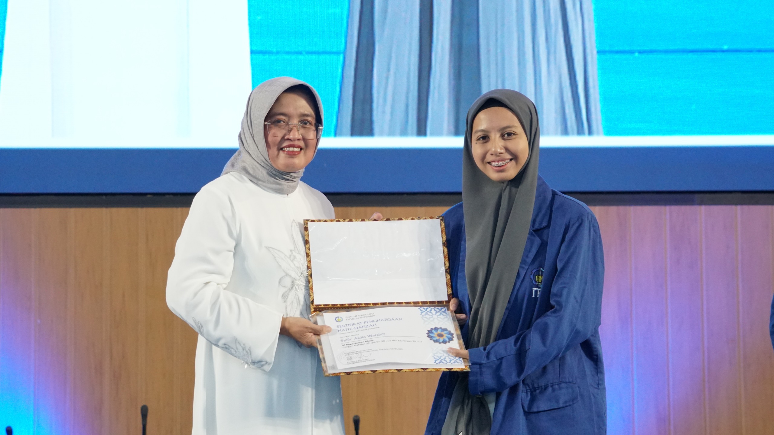 Penyerahan apresiasi penghargaan secara simbolis kepada hafiz dan hafizah berprestasi ITS oleh Wakil Rektor I ITS Prof Nurul Widiastuti SSi MSi PhD (kiri) kepada mahasiswa Departemen Kimia ITS Syifa’ Aulia Wardah