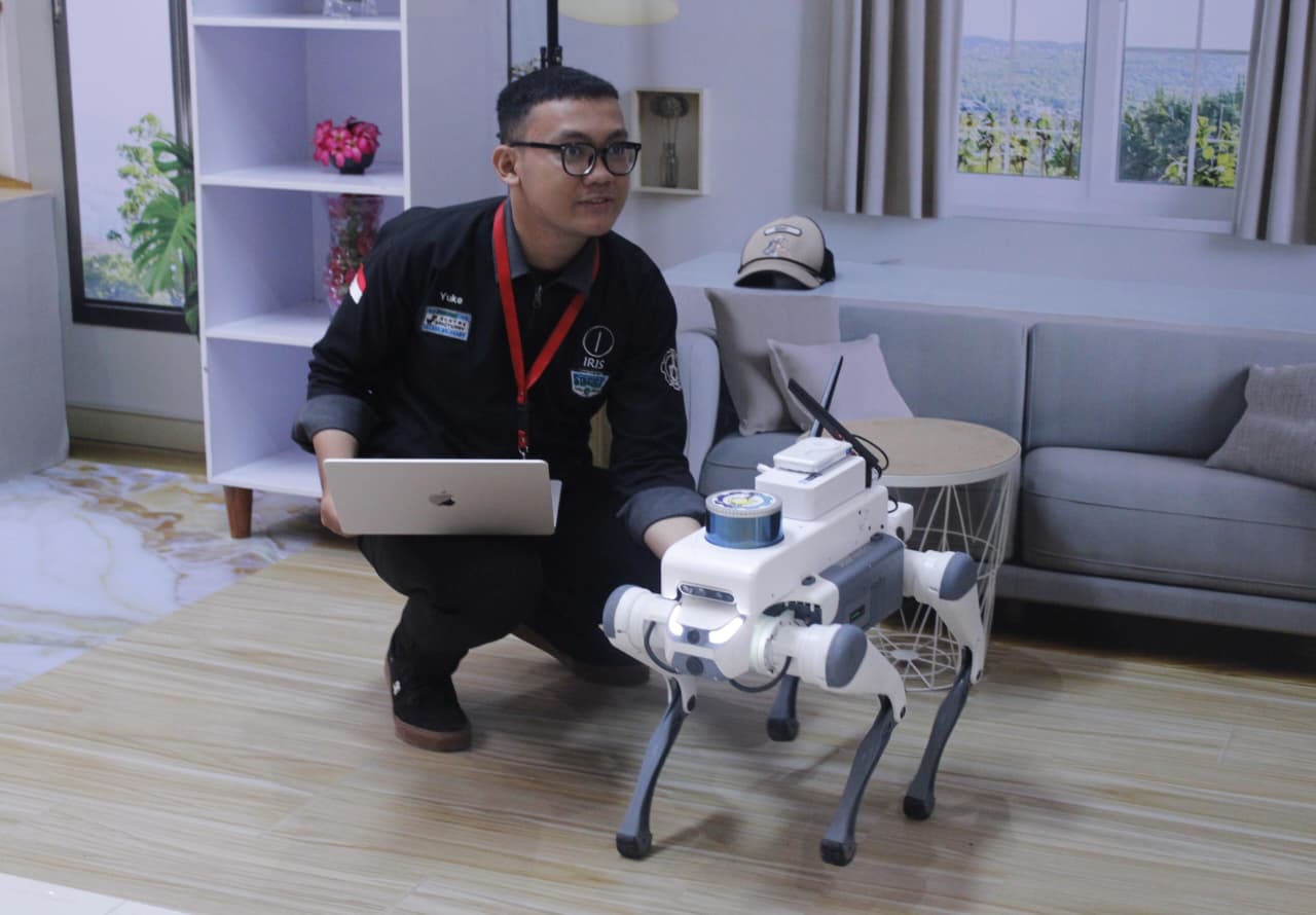 Perwakilan Pengembang RoboDog ITS Yuke Brilliant Hestiavin saat mempersiapkan RoboDog untuk demonstrasi pengendalian jarak jauh di Kantor Indosat Surabaya
