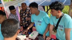 Tim EPICS in IEEE 2026 ITS menjelaskan cara kerja sistem penyediaan air berbasis panel surya terintegrasi Internet of Things (IoT) kepada warga di Desa Cokrokembang, Pacitan
