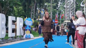 Kepala Biro Manajemen Aset ITS Yayuk Pamikatsih dengan bangga mengenakan busana adat dari Papua saat melenggang di atas karpet catwalk ITS Kartini Fashion Day 2026 di area Bundaran ITS