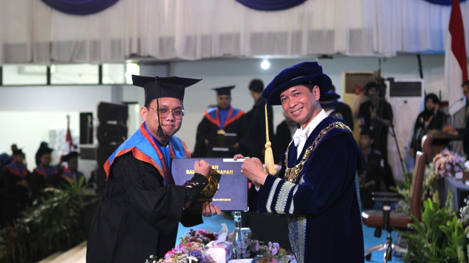Handover of the diploma by ITS Rector Prof Ir Bambang Pramujati ST MScEng PhD to one of the graduates from the ITS Civil Infrastructure Engineering Department, Gandhi Kesuma
