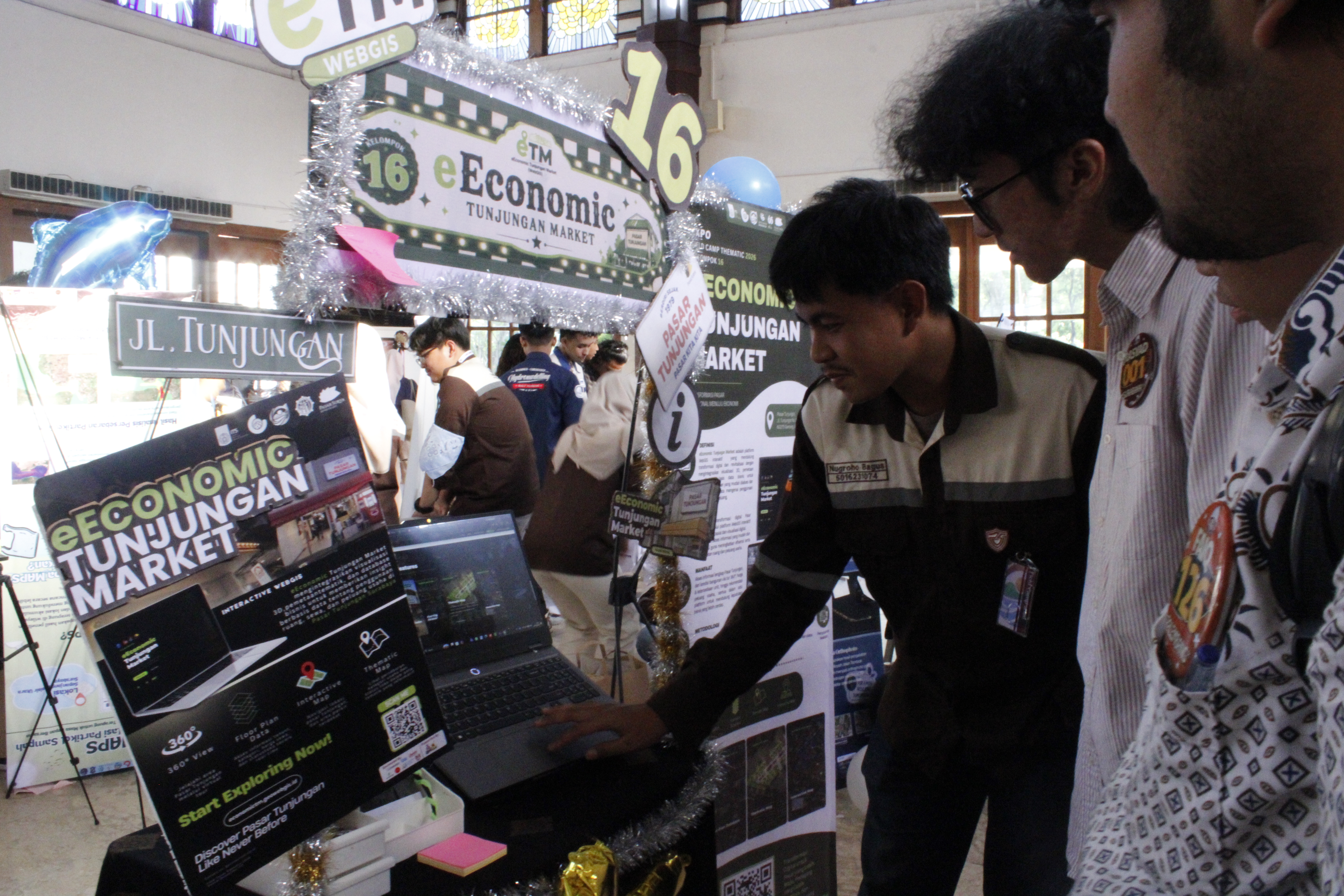 Mahasiswa peserta pameran Vectra Expo 2026 saat menjelaskan karyanya yang bertajuk e-Economic Tunjungan Market kepada para pengunjung