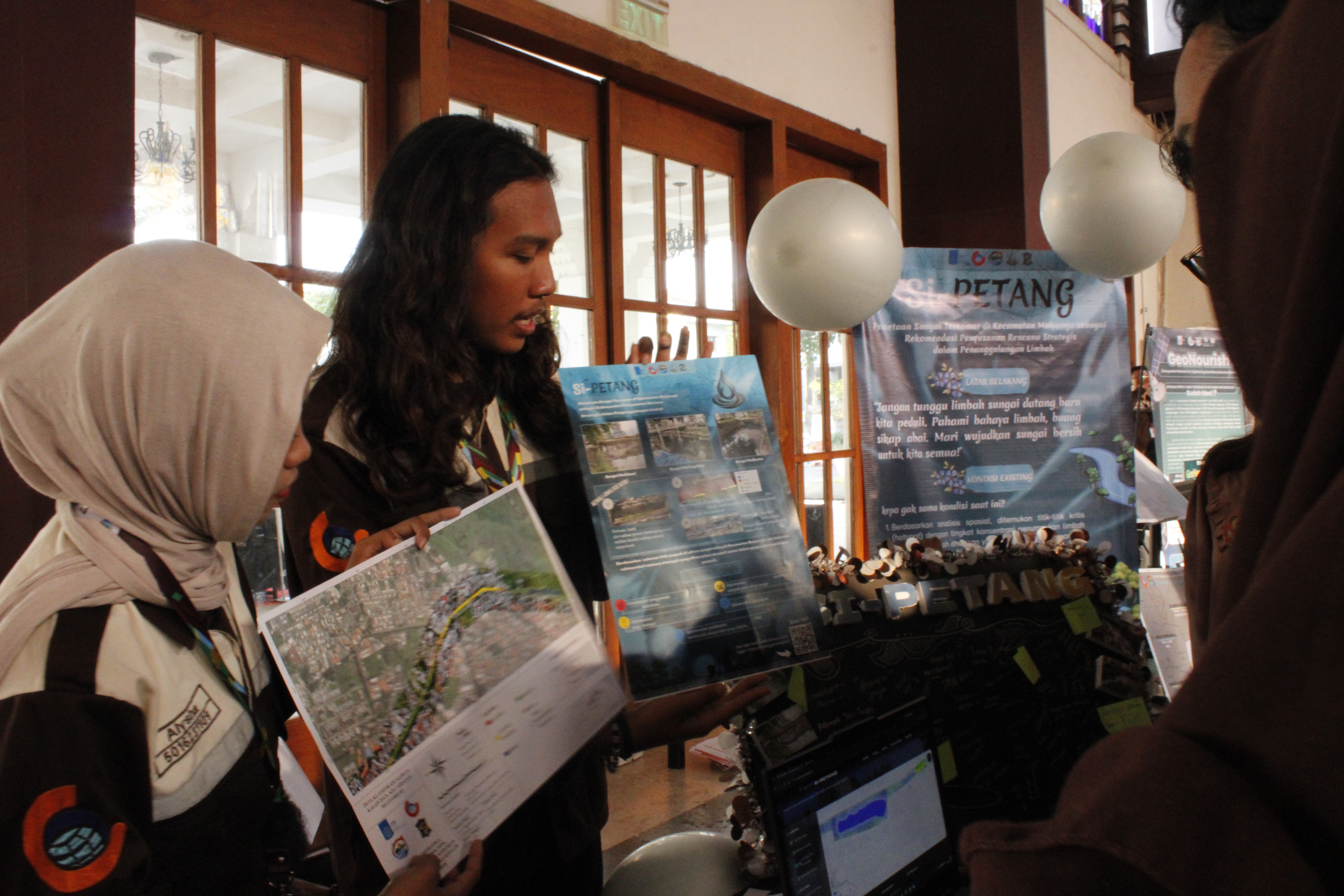 Salah satu mahasiswa saat menjelaskan karyanya berjudul si-PETANG yang memanfaatkan teknologi pemetaan untuk mengidentifikasi sungai tercemar di Kecamatan Mulyorejo, Surabaya dalam pameran Vectra Expo 2026