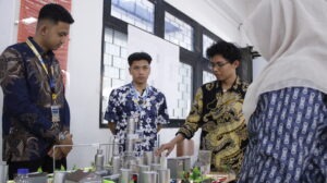 Salah satu kelompok Program Global Summer Course Initiative 2026 saat memaparkan konsep mock-up pabrik kepada salah satu juri (pojok kanan)