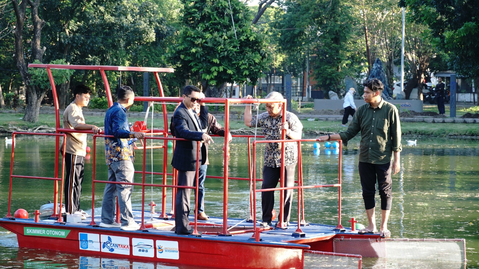 Rektor ITS Prof Dr (HC) Ir Bambang Pramujati ST MScEng PhD (berjas) bersama tim peneliti Kapal Pembersih Sampah Tanpa Awak melakukan uji coba kapal di danau Infinits ITS