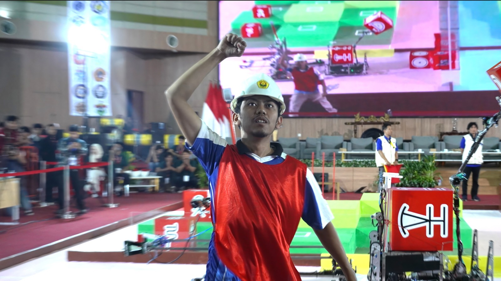 Salah satu anggota Tim Richie ITS langsung melakukan selebrasi selepas sukses mengungguli tim robot UNY dengan total skor 160 pada babak final Kontes Robot ABU Indonesia (KRAI) 2026 di Universitas Jember