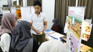 Salah satu mahasiswa Departemen Desain Interior ITS saat memamerkan karya Tugas Akhir (TA)-nya di hadapan pengunjung
