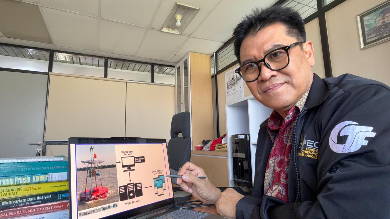 Prof Dr Ir Syamsul Arifin MT menunjukkan bagan arsitektur transmisi data Buoy Weather Tipe II berbasis IoT di Laboratorium Embedded and Cyber-Physical Systems