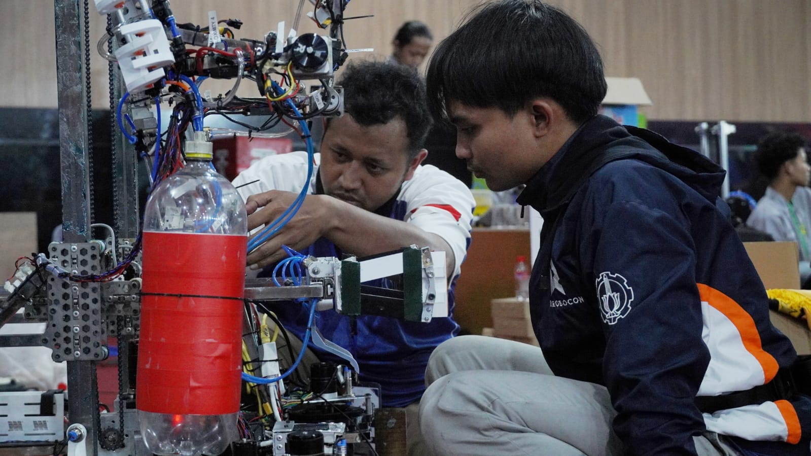 Dosen Pembimbing Tim ABU Robocon ITS Muhammad Lukman Hakim ST MT dan Ketua Tim ABU Robocon ITS Muhammad Najmi Ihsan meninjau permasalahan pada robot