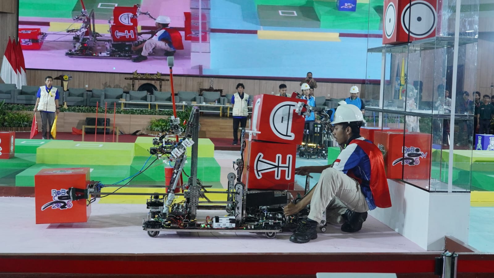 Salah satu anggota Tim Richie Robocon ITS hendak memindahkan robot dari arena pertandingan