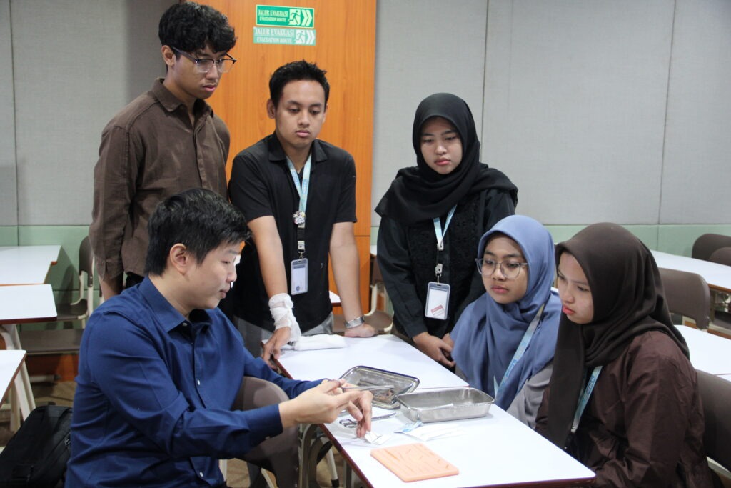 Gambar dr Ivor Wiguno Hartanto Wilopo SpB FINACS dalam memberikan pelatihan terkait penjaitan luka pada materi tata laksana kedaruratan bedah pada bencana