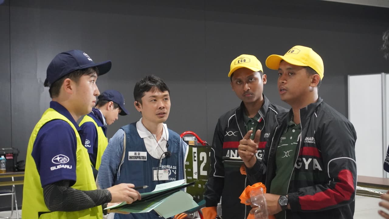 Gambar Tim Anargya ITS (kanan) ketika menjelaskan spesifikasi dan cara kerja mobil formula listrik Mark 6.0 kepada salah satu juri FSAE Japan 2026 (kiri)