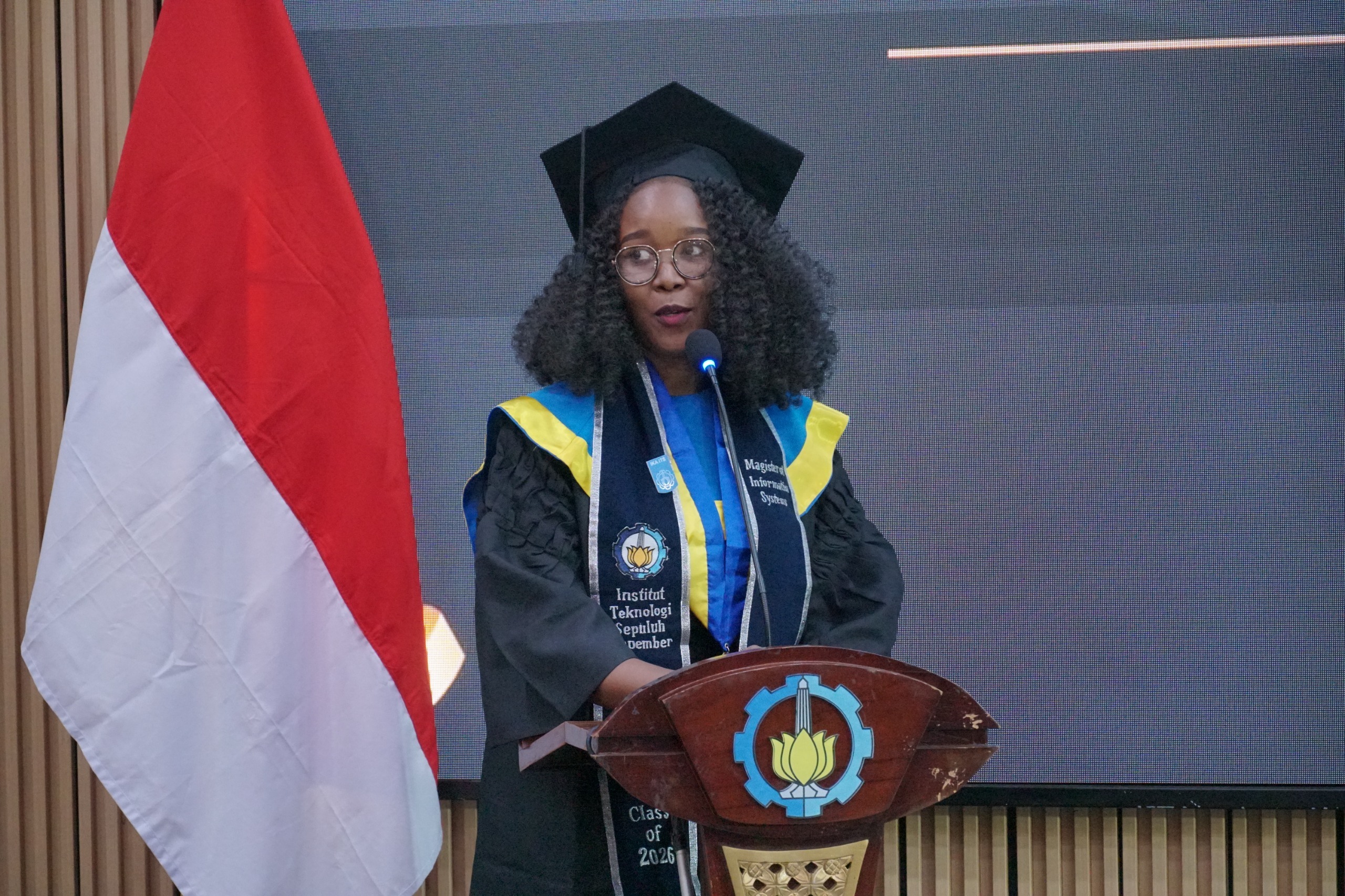 wisudawan S2 FTE-IC Treza Nyanchama Ogeto berdiri di atas panggung dan membagikan kisah harunya saat wisuda khusus mahasiswa internasional.