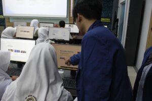 Peserta pelatihan coding AI ketika dibimbaing secara langsung oleh salah satu mahasiswa tim KKN Departermen Teknik Informatika ITS