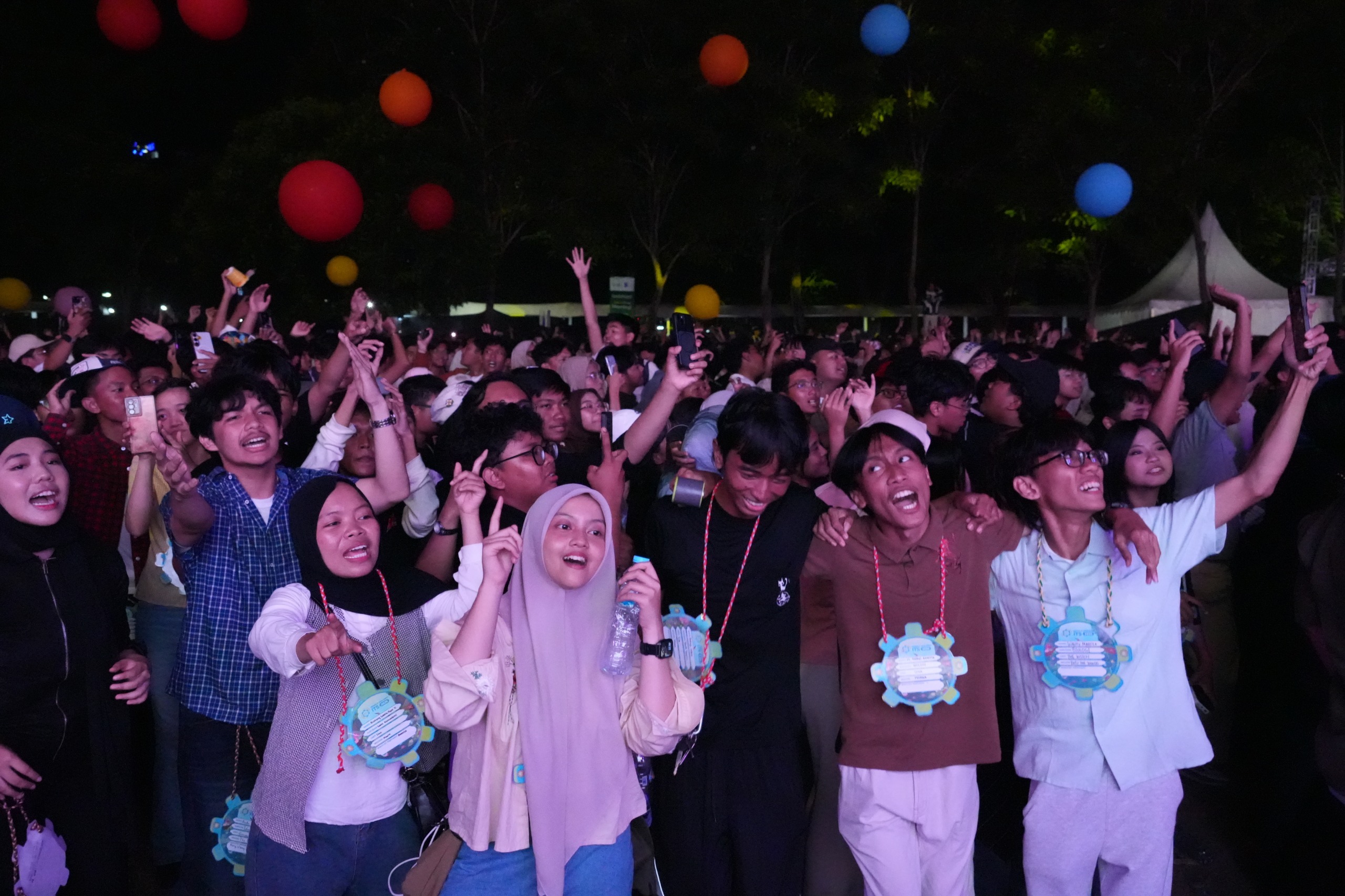 Maba ITS 2026 bernyanyi bersama sembari menikmati balon warna-warni yang menghiasi area penonton