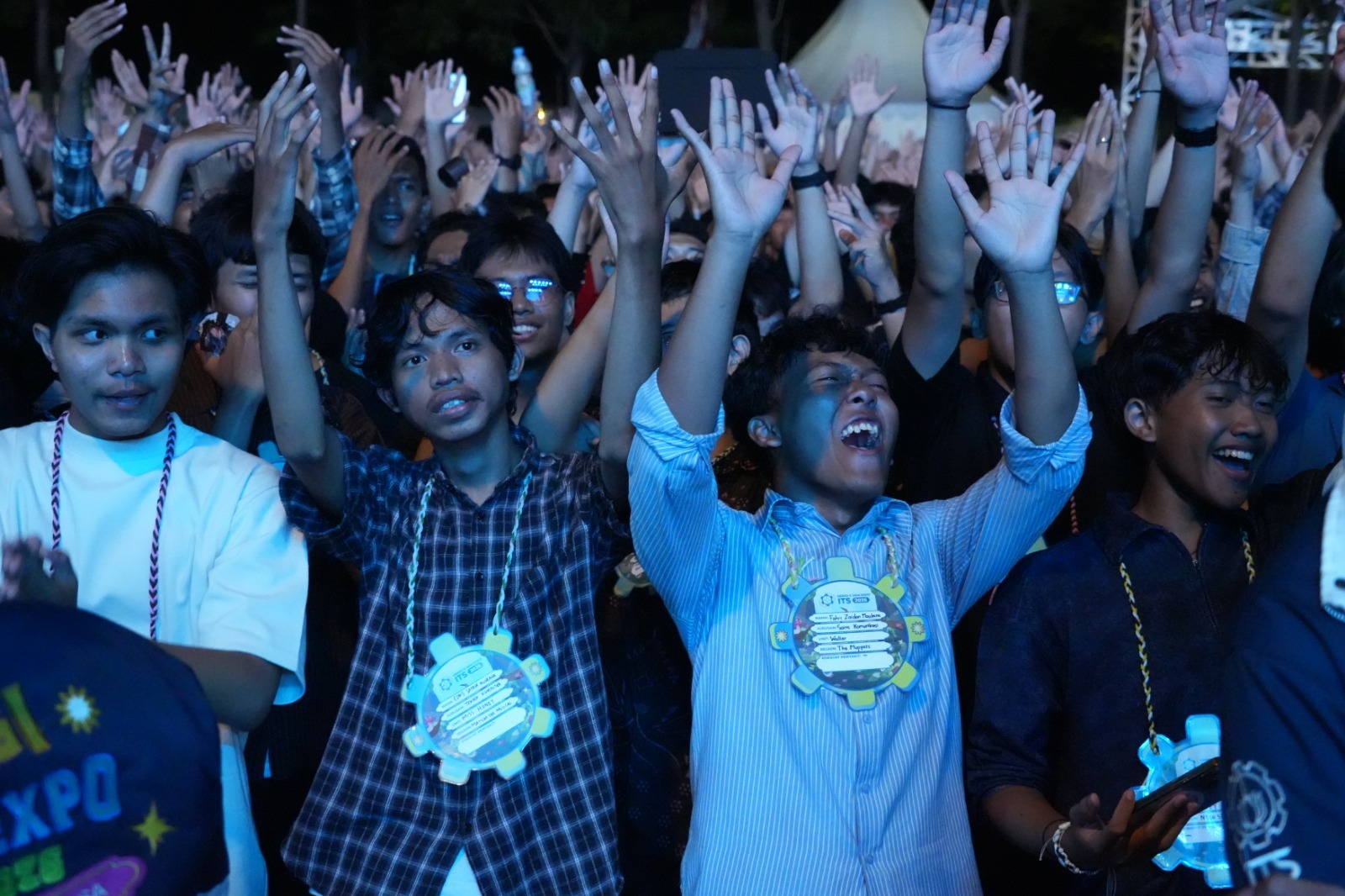 Antusiasme maba ITS 2026 mengikuti penampilan HIVI! dengan mengangkat tangan bersama di tengah kerumunan