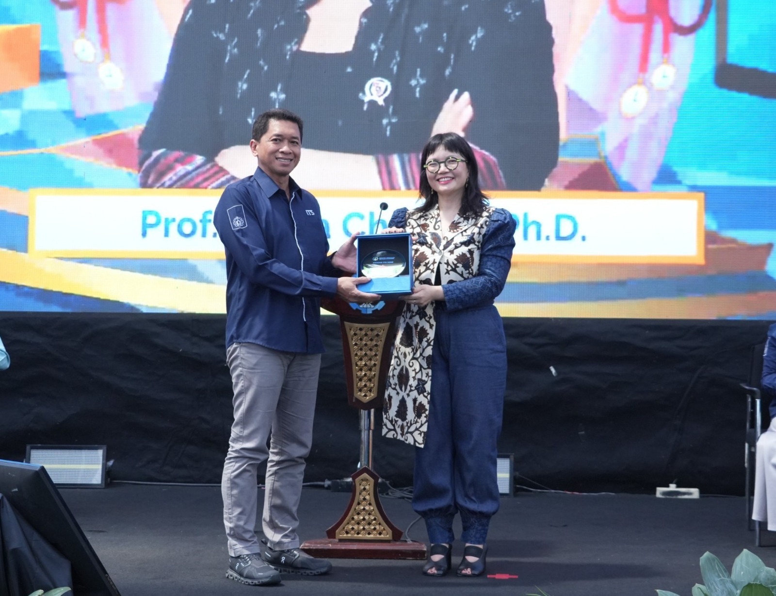 Rektor ITS Prof Dr (HC) Ir Bambang Pramujati ST MScEng PhD (kiri) serahkan cinderamata kepada Wamen Diktisaintek RI Prof Stella Christie PhD usai menjadi pemateri di PKKMB ITS