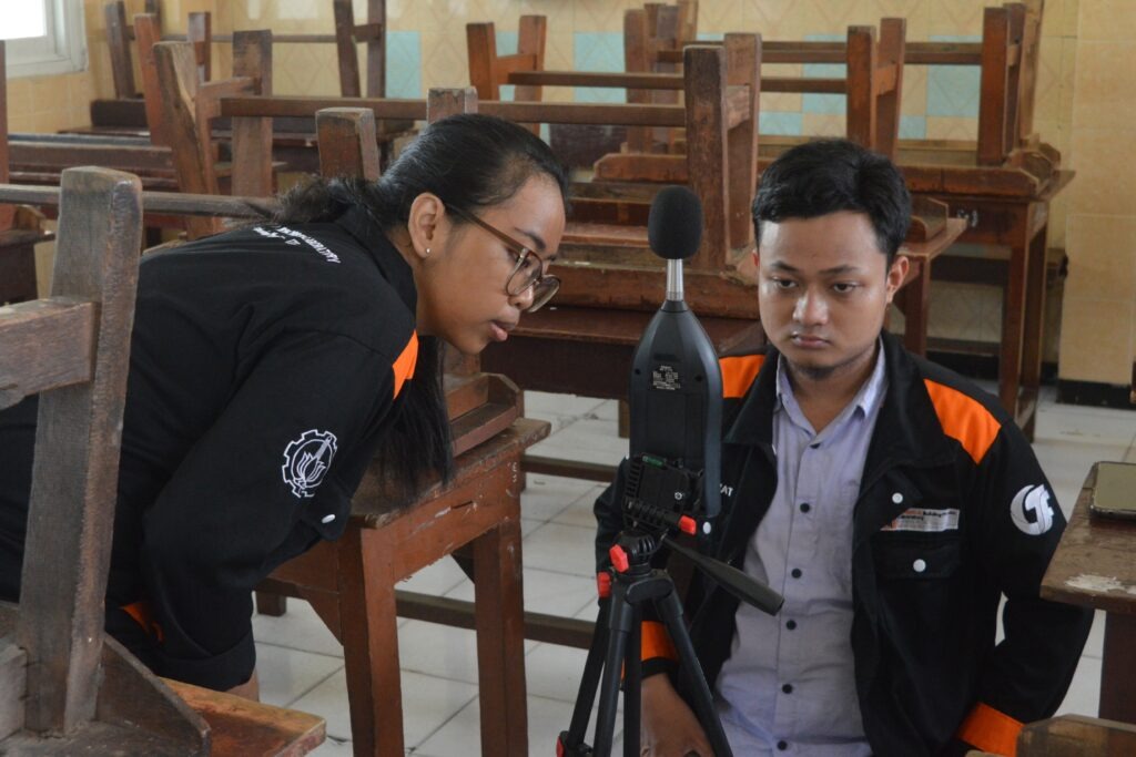 Tim abmas ITS sedang membaca data hasil pengukuran tingkat kebisingan pada instrumen Sound Level Meter (SLM)