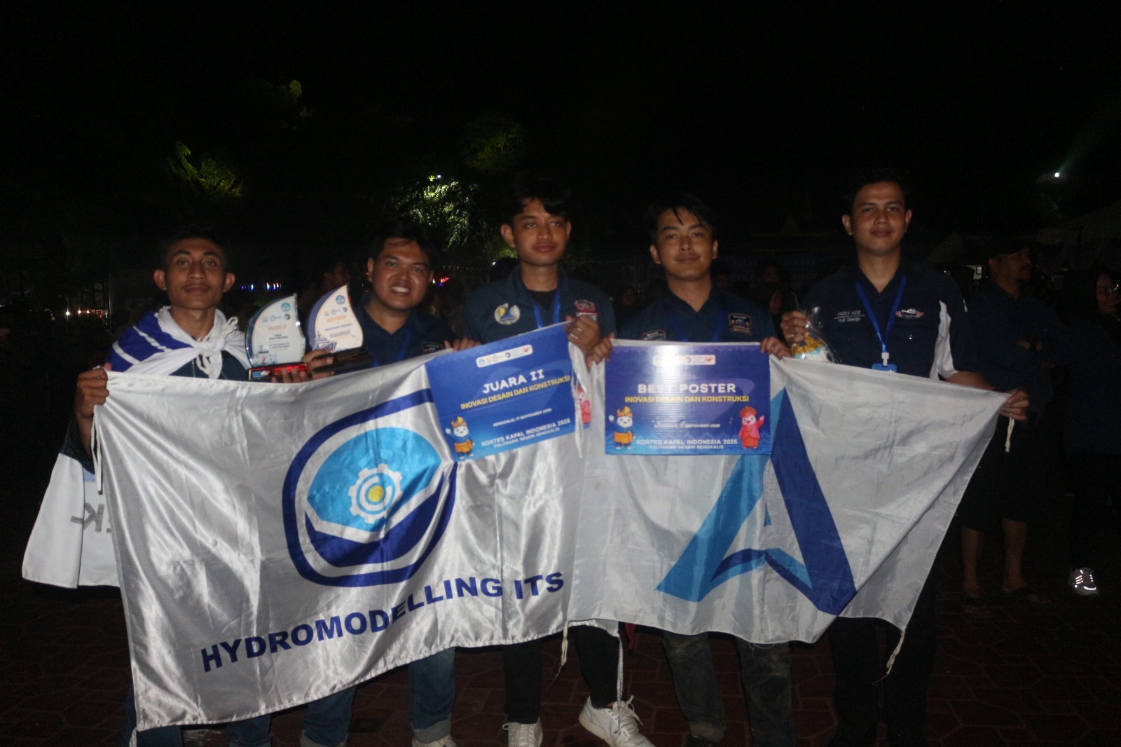 Tim Hydromodelling X Arkana ITS usai meraih Juara 2 dan gelar Best Poster pada kategori Inovasi Desain Konstruksi (IDK) di ajang Kontes Kapal Indonesia (KKI) 2026