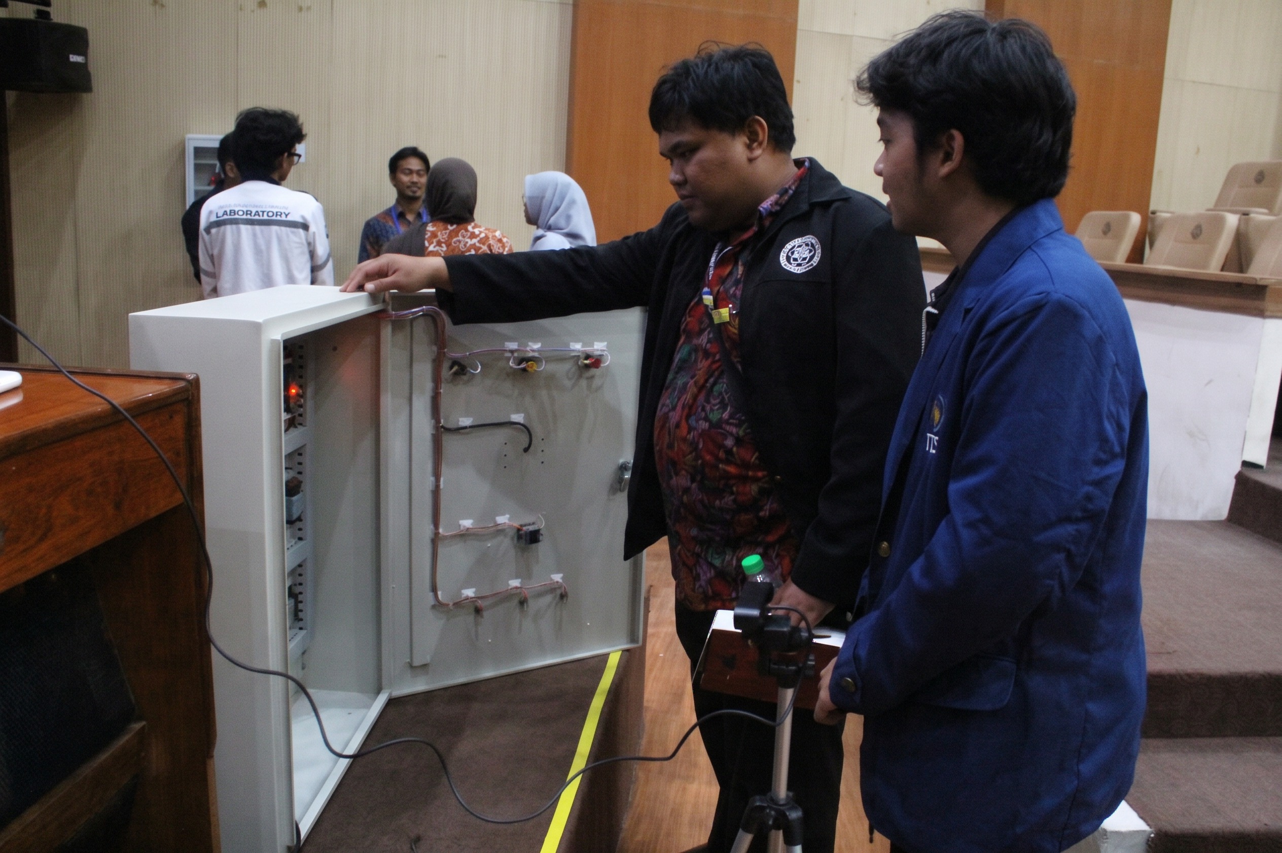 Potret salah satu hadirin melihat isi dari alat Smart Energy Monitoring System