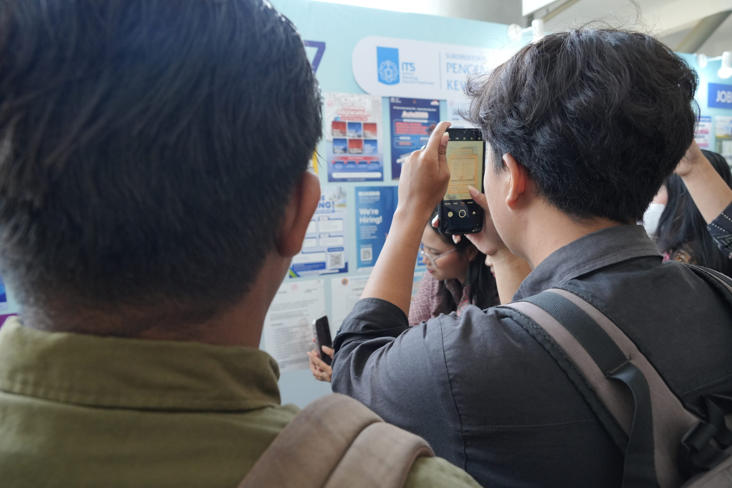 Salah satu peserta BKI ke-47 memindai poster lowongan kerja