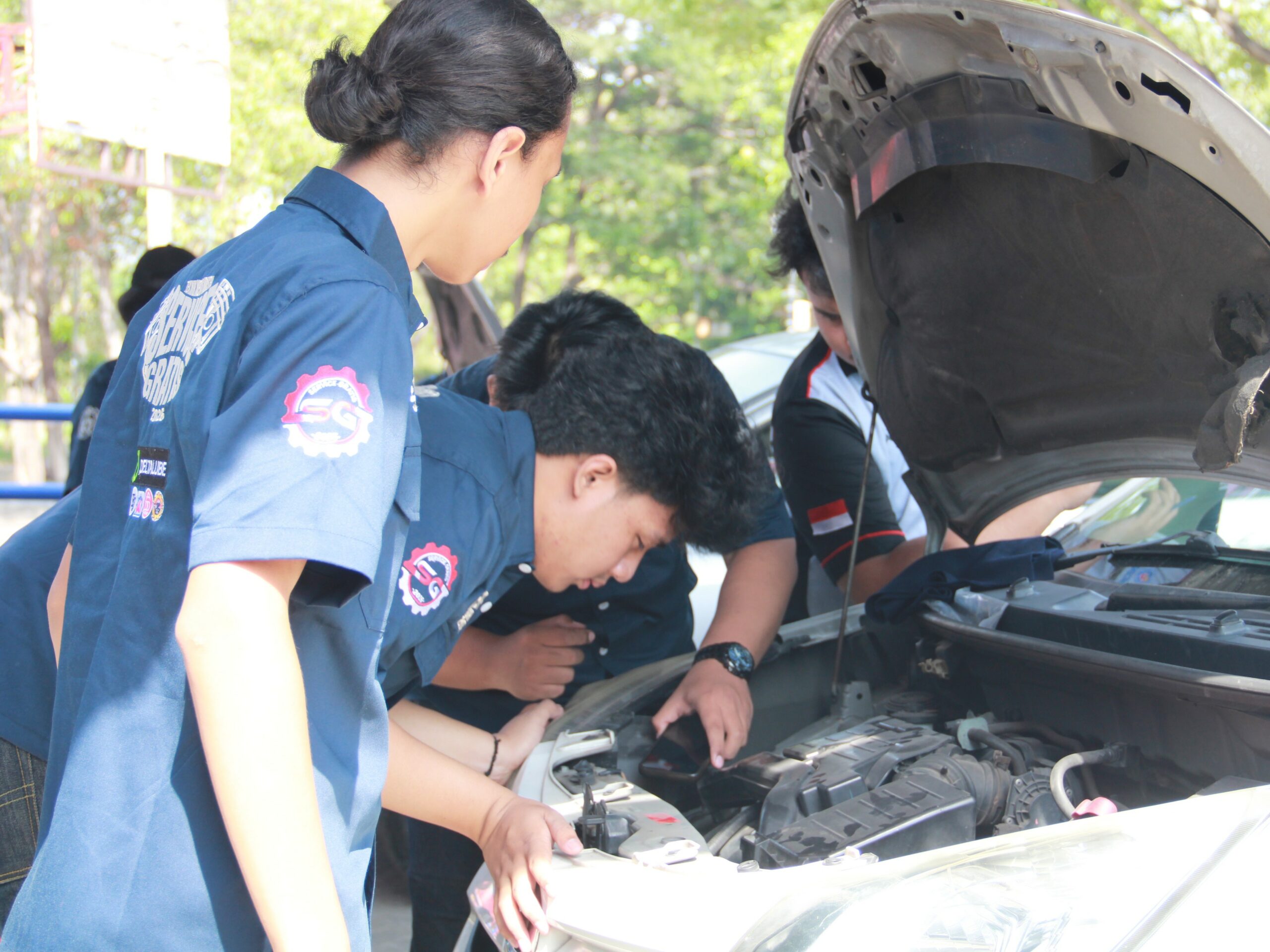 Mahasiswa Departemen Teknik Mesin Industri saat melakukan pengecekan kondisi mobil pada kegiatan Servis Gratis DTMI ITS 2026