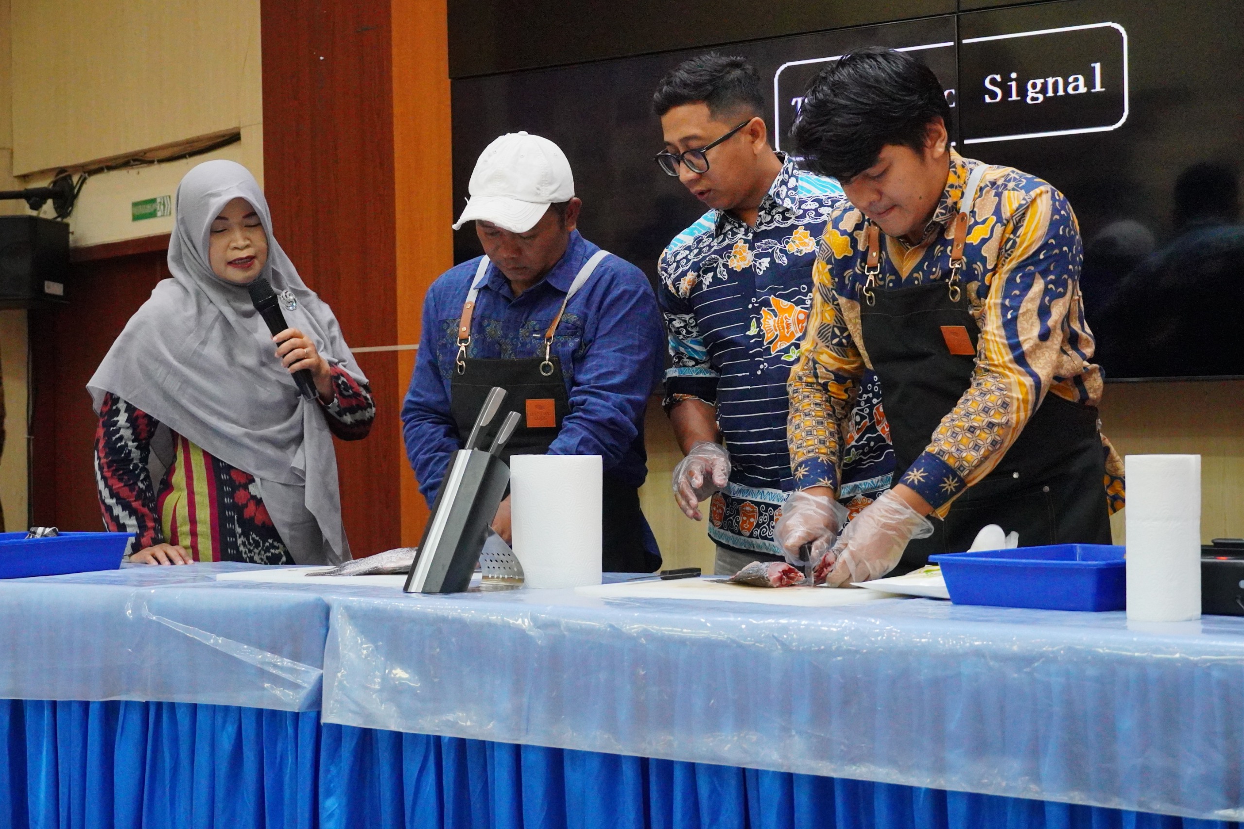 Wiwin Sumiati SPi MSi bersama tim dari Dinas Kelautan dan Perikanan mempraktekkan cara fillet ikan nila hasil budidaya