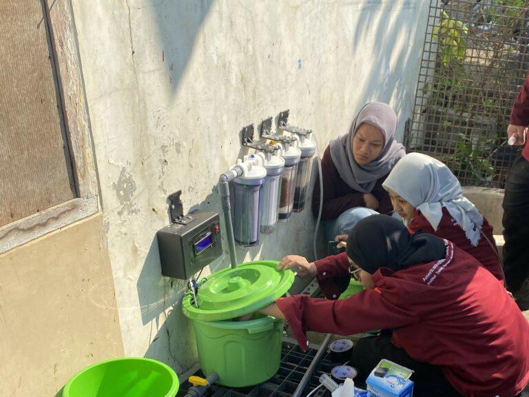 AIChE ITS SC team members installing the IoT-based well water filtration unit in the Keputih Tegal Bakti residential area.