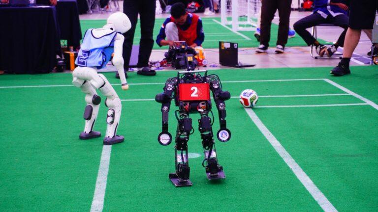 The Ichiro ITS humanoid robot (right) competes on the green field at RoboCup 2026 at Songdo Convensia, Incheon, South Korea.