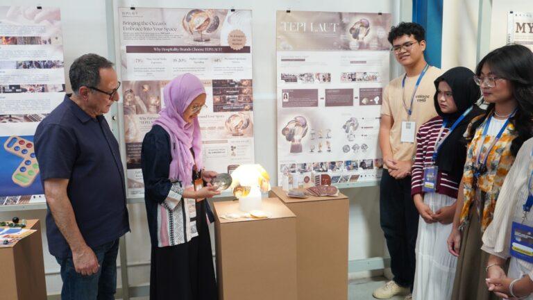 Dr. Qassim Saad (left) and Dean of FDKBD ITS Ellya Zulaikha, S.T., M.Sn., Ph.D. (second from left) examine one of the innovative student works from ITS, a lamp fixture made from kapis seashells.