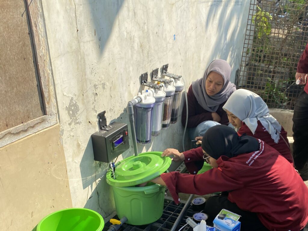 Tim AICHe ITS SC saat memasang Unit filtrasi air sumur berbasis IoT yang di pemukiman warga Keputih Tegal Bakti
